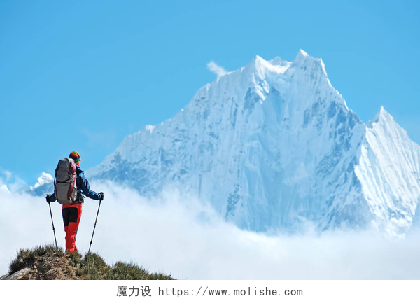 蓝天白云下徒步旅行的登山者在尼泊尔喜马拉雅山背着背包的徒步旅行者。积极运动理念.